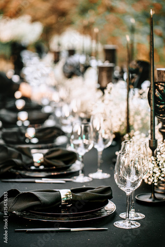Wallpaper Mural Serving and decorating a banquet table in black with white flowers and black candles at an outdoor party