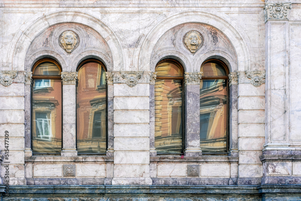 Four arched windows with a bas-relief of a lion's head against a marble stone wall. From the Windows of the world series.