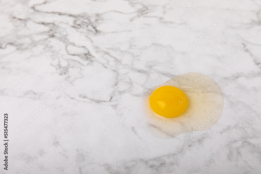 Broken quail egg on the surface. Quail eggs on a white marble background. Natural products. Place for text. fresh eggs Broken quail egg on the surface. Quail eggs on a white marble background. Natural products. Place for text. fresh eggs