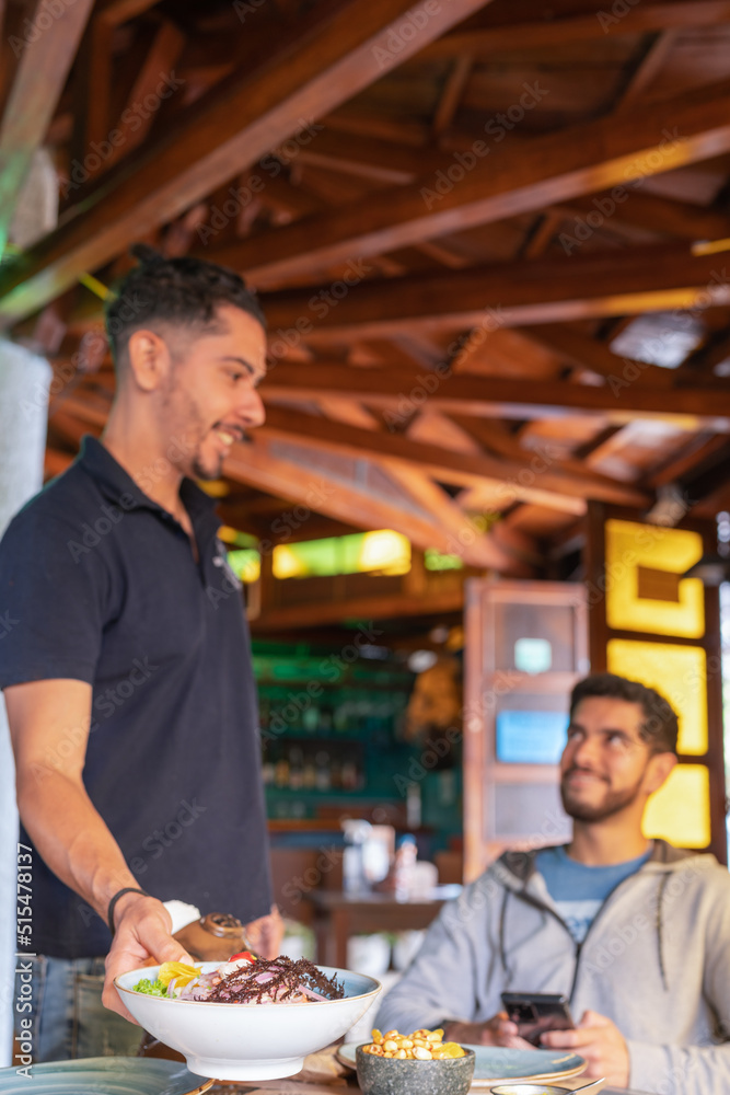 waiter serving ceviche to a table with customers in a restaurant