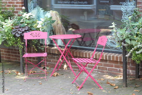 The pink table and chairs are in front of the popular cafe.