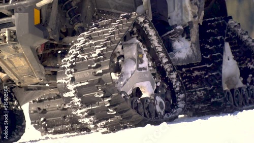 snowcat rises up the mountain. caterpillars on snowmobiles close-up. Snowcat in action on the morning ski run. Ski slope preparation machine. Tracked vehicle for heavy equipment mining.
