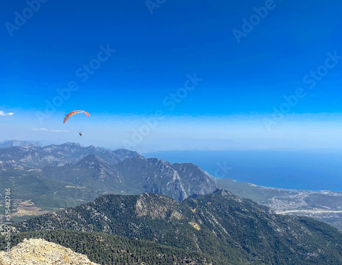paratroopers fly through the air. jump down on a paraglider. view of the city from a height of flight. paragliding with mountain view