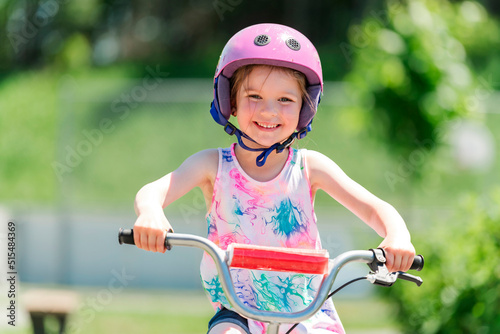 Children learning to drive a bicycle on a driveway outside. Little girls riding bikes on asphalt.