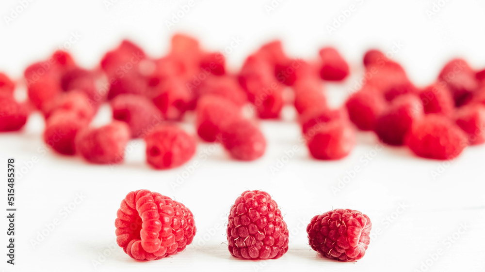 Naklejka premium Fresh red raspberries on a white table background