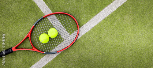 Obraz na płótnie tennis balls and racket on green synthetic grass court background