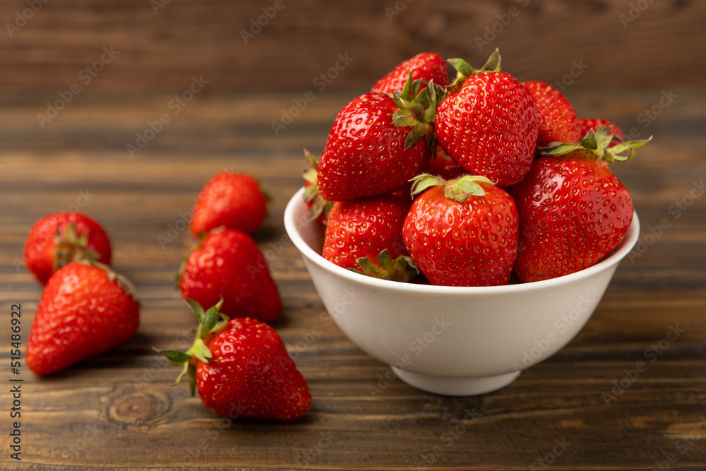 Fresh ripe strawberries in a bowl on a brown texture background.Vegetarian organic berry.Healthy food.Copy space.Place for text Fresh ripe strawberries in a bowl on a brown texture background.Vegetarian organic berry.Healthy food.Copy space.Place for text