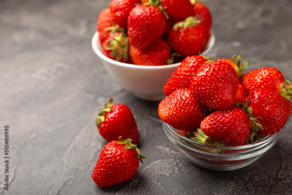Fresh ripe strawberries in a plate on a black texture background.Vegetarian organic berry.Healthy food.Vitamins.Copy space.Place for text Fresh ripe strawberries in a plate on a black texture background.Vegetarian organic berry.Healthy food.Vitamins.Copy space.Place for text