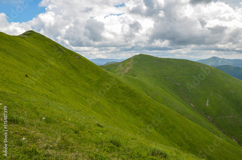 Εκτύπωση καμβά Green mountain ridge with steep slopes and high peak with a cross in the distance