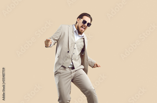 Overjoyed businessman in suit and glasses isolated on nude brown studio background celebrate win or success. Smiling man in formalwear scream and shout feel euphoric excited with promotion.