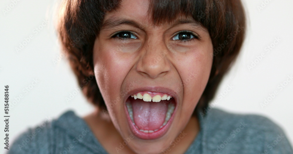 Upset child screaming. Mixed race Kid yelling roaring to camera, close-up angry boy face Upset child screaming. Mixed race Kid yelling roaring to camera, close-up angry boy face
