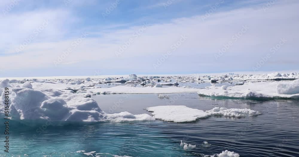 A rigid inflatable boat powers across the glacier lagoon at Kulusuk, Greenland - The result of global warming and climate change on our planet - Snowy mountain range reflection on the sea, Greenland A rigid inflatable boat powers across the glacier lagoon at Kulusuk, Greenland - The result of global warming and climate change on our planet - Snowy mountain range reflection on the sea, Greenland