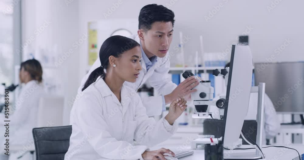 Two scientist using a computer and microscope while conducting medical research in a lab. Innovative biochemists making breakthrough and discovery in a hospital facility while using online technology