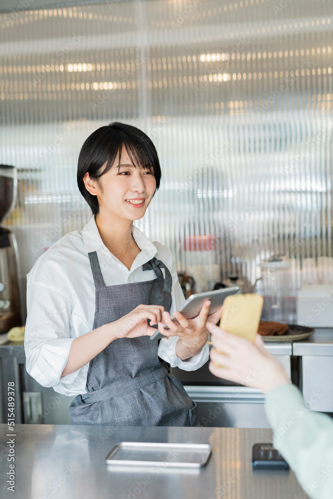 カフェ スタッフにスマートフォンを見せる女性 カフェ スタッフにスマートフォンを見せる女性