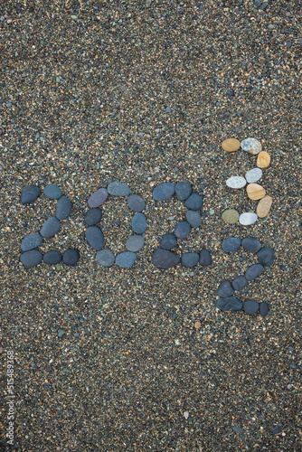 Flipping of 2022 to 2023 made from stones on beach.
