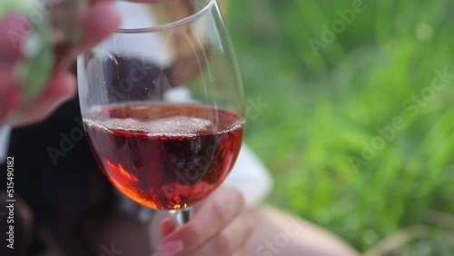 Glass glass filled with red wine. Taster pours alcoholic beverage against the backdrop of the sunset. Romantic dinner in nature. oxidation of wine, oxygenation. 