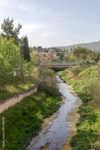 View of the river, bridge and houses in the village (Greece) on a spring day