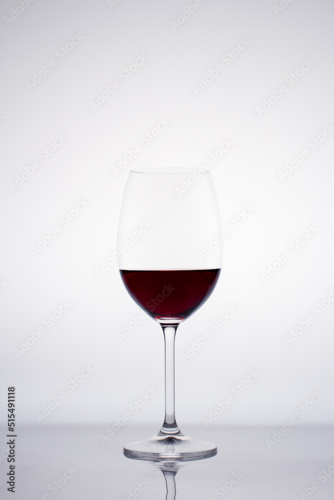 Glass of red wine in back light on white background Glass of red wine in back light on white background