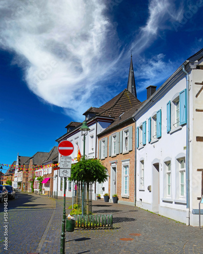 Wachtendonk, Germany - July 2. 2022: Typical lower rhine (Niederrhein) empty cobblestone street in german village with old colorful houses