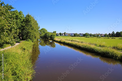 Beautiful german rural countryside scenic landscape, riverside cycling path, green forest and meadow, blue summer sky - Wachtendonk, Germany