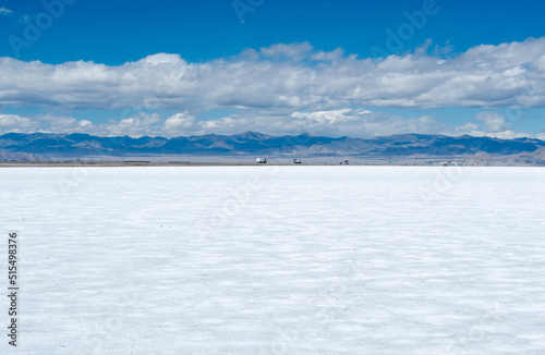 Glittering white Salt Flats in Utah, United States with cars and trucks on a highway in the distance. © Chelsea Sampson