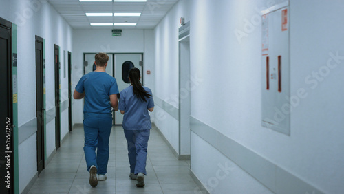 Doctors colleagues walking down corridor talking about work. Medics consulting.