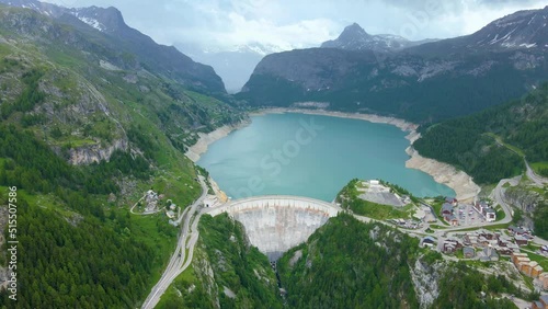 Water dam and reservoir lake aerial drone footage in French Alps mountains generating hydroelectricity. Low CO2 footprint, decarbonize, renewable energy, sustainable development. 4K 60fps video.