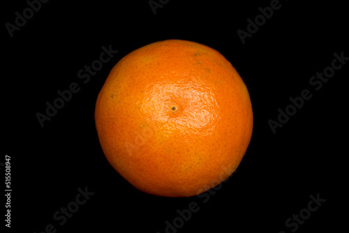 tangerine lies on a black background