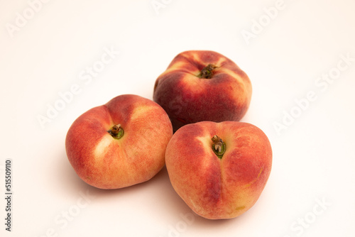 Donut peaches in front of a yellowish white background