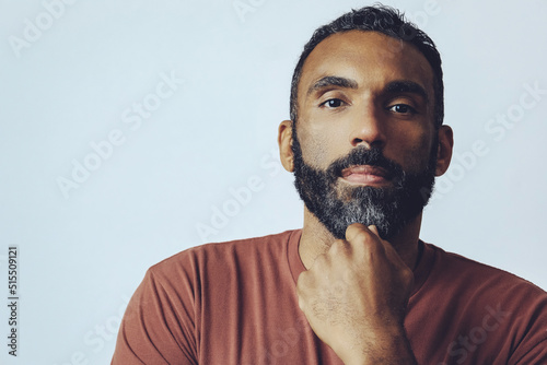 headshot portrait of a handsome bearded mid adult man looking at camera against gray background studio shot