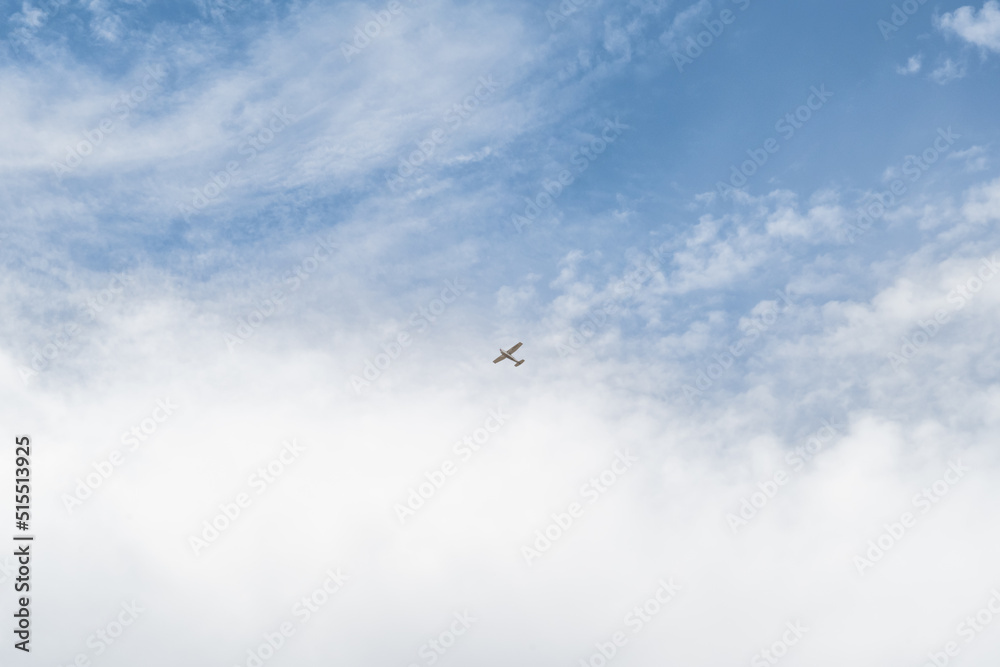 petit avion bi-moteur dans les nuages du ciel
