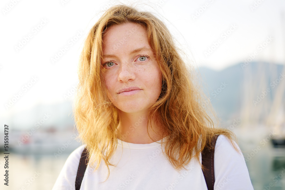 Portrait of charming young tourist woman on the Mediterranean coast. Attractive red-haired girl hiking by the sea shore. Portrait of charming young tourist woman on the Mediterranean coast. Attractive red-haired girl hiking by the sea shore.