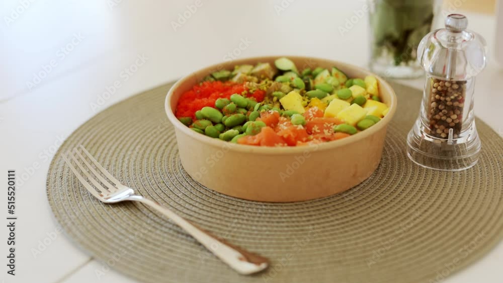 Poke bowl with salmon, rice, avocado, edamame beans, cucumber and radish in gray bowl. Hawaiian ahi poke bowl, gray background. Poke bowl with salmon, rice, avocado, edamame beans, cucumber and radish in gray bowl. Hawaiian ahi poke bowl, gray background.