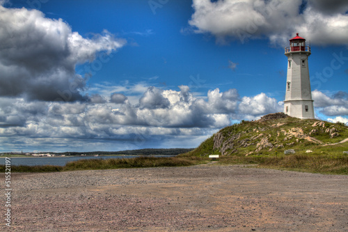 historic lighthouse with dramatic clouds and road