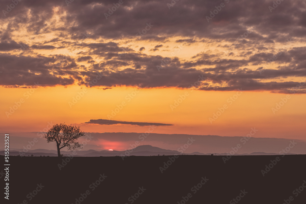 Beautiful sunset on rural landscape.Mountains in background.