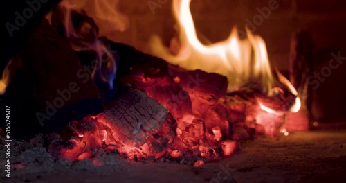 Close-up of adding wood to woodfire oven - pizza oven