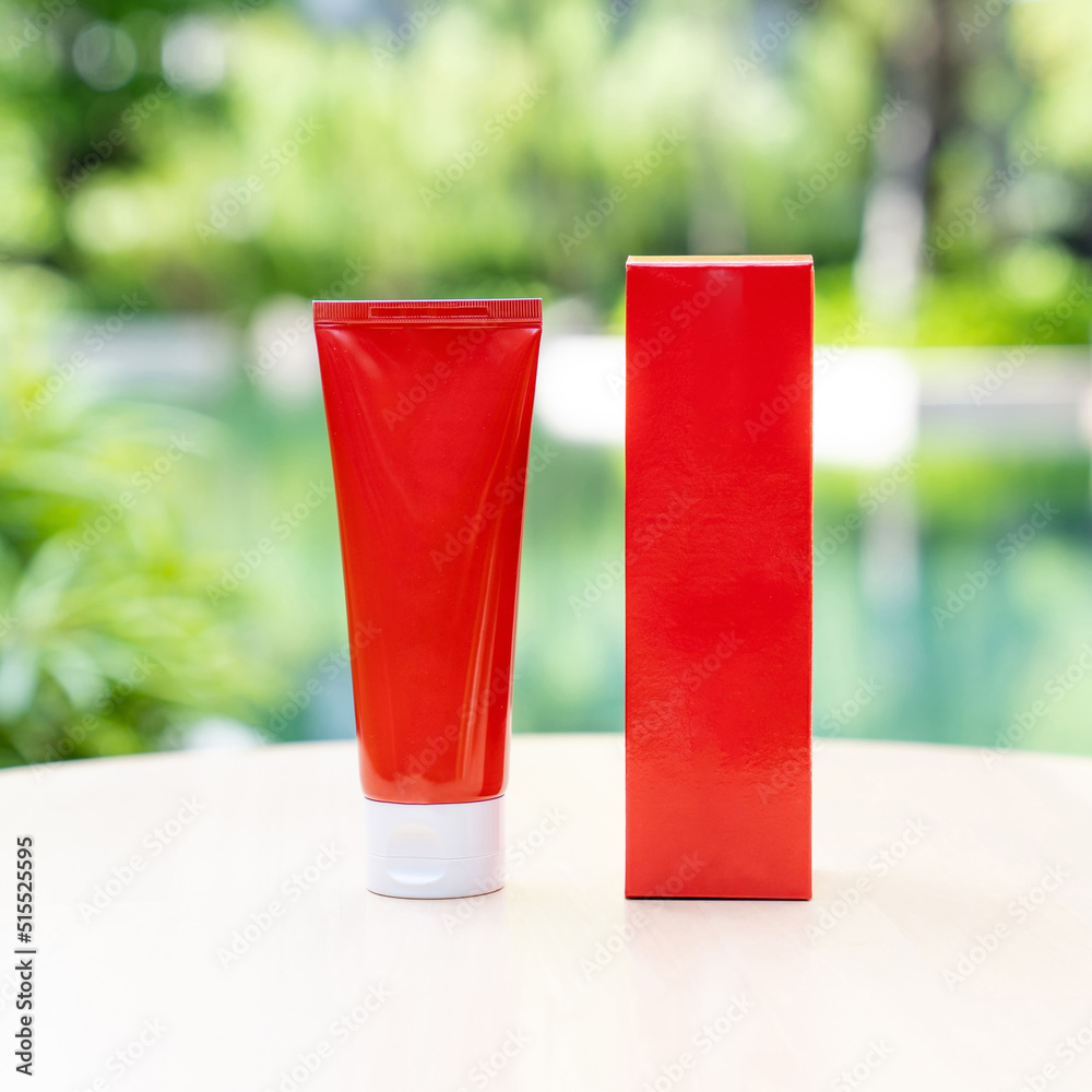 RED long tubes have a front and back view surrounded by left outside on a sunny day with blur nature green background. Suitable for product samples or demo images for advertisement. Clipping Path.. RED long tubes have a front and back view surrounded by left outside on a sunny day with blur nature green background. Suitable for product samples or demo images for advertisement. Clipping Path..