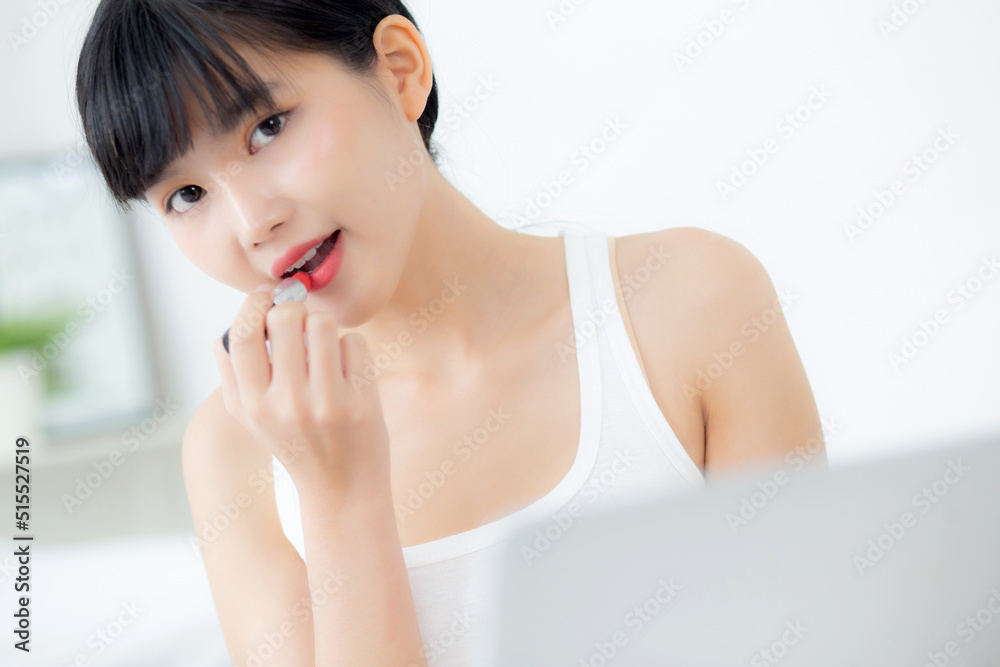 Beauty of young asian woman with learning makeup with lipstick on mouth watching laptop computer with tutorial course online, female teaching and explain make up with cosmetic on streaming media. Beauty of young asian woman with learning makeup with lipstick on mouth watching laptop computer with tutorial course online, female teaching and explain make up with cosmetic on streaming media.