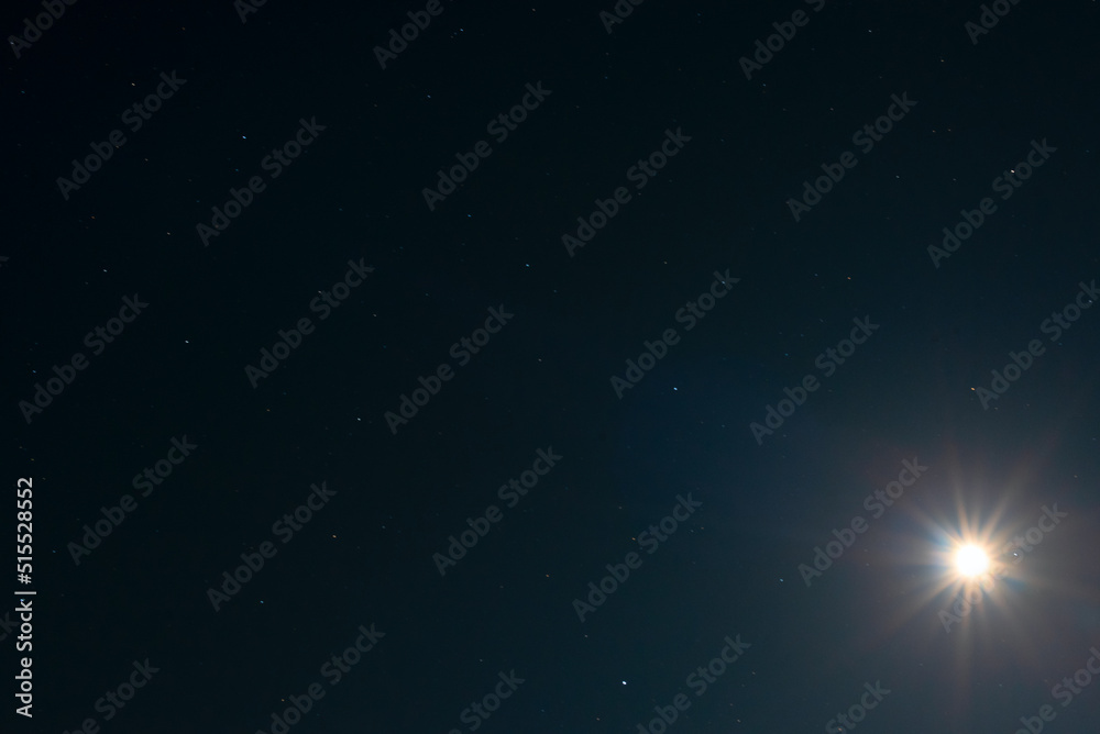 Night sky background with moon shining like a big star on black sky with a stars. Astro photo on summer night