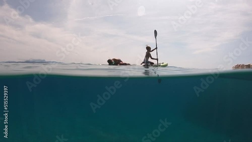 Little boy on a paddleboard.
Cute child learning on a paddleboard.