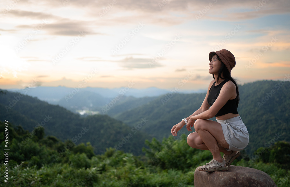 Asian female pondering over the fog rolling through the forrest and mountains during sunset. Relaxing over a picnic during the tough times.Holiday travel and enjoy in camping lifestyle concept. Asian female pondering over the fog rolling through the forrest and mountains during sunset. Relaxing over a picnic during the tough times.Holiday travel and enjoy in camping lifestyle concept.