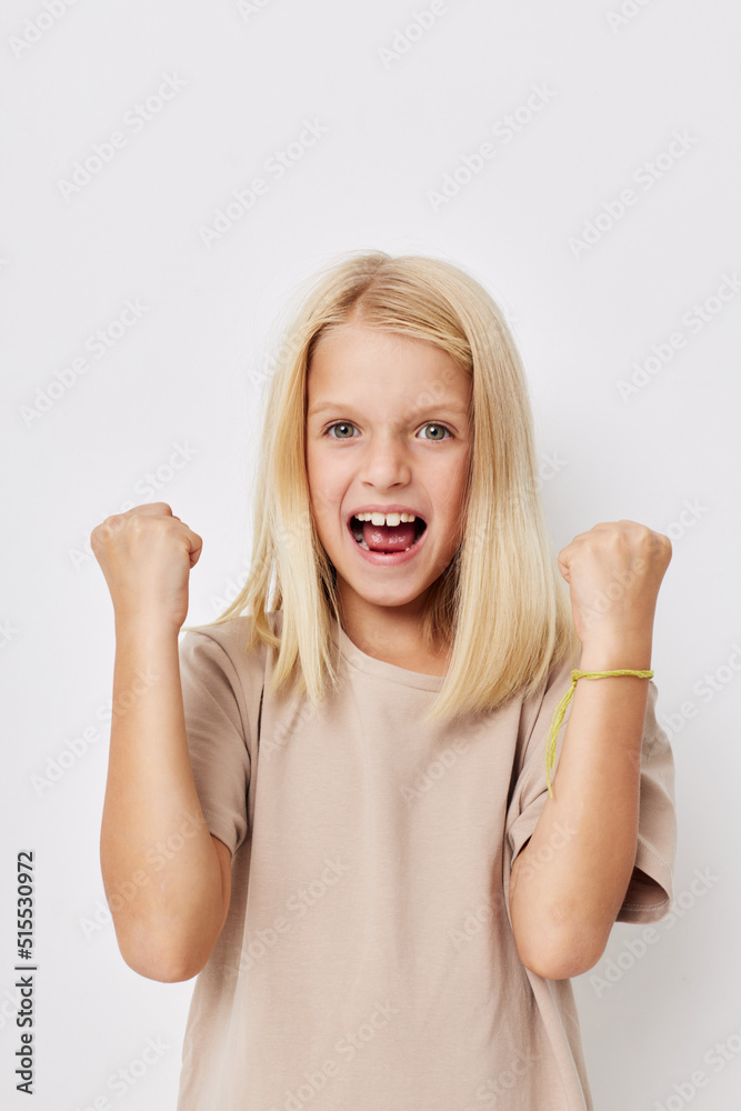 Positive little girl with blond hair on a light background Positive little girl with blond hair on a light background