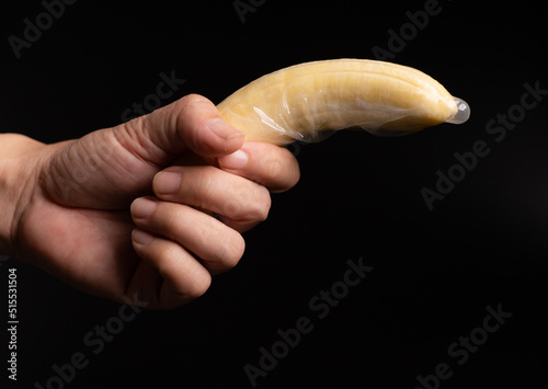 condom, hand hold banana with condom, sex education concept.