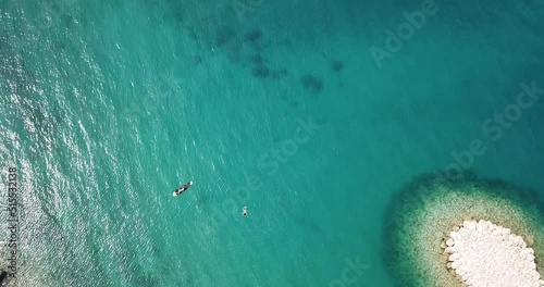 Young woman and little boy on paddleboard.
Mother with her son riding a paddleboard. Shot against sunlight.