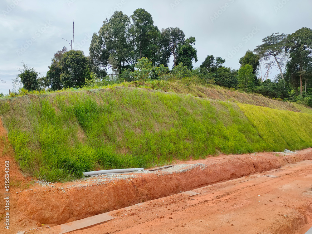 Permanent slope protection with grass using the hydroseed method. The grass is used to stabilize the slope structure and prevent slope erosion. Effective and less maintenance. 