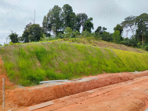 Permanent slope protection with grass using the hydroseed method. The grass is used to stabilize the slope structure and prevent slope erosion. Effective and less maintenance. 