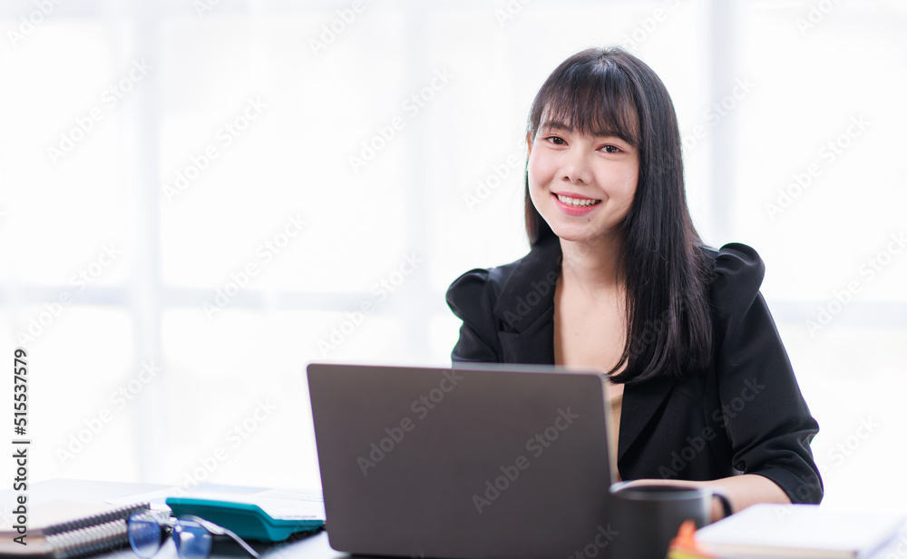 Portrait of a smiling Asian Business woman using modern technology, working over the laptop. Portrait of a smiling Asian Business woman using modern technology, working over the laptop.