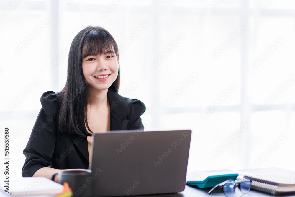 Portrait of a smiling Asian Business woman using modern technology, working over the laptop. Portrait of a smiling Asian Business woman using modern technology, working over the laptop.