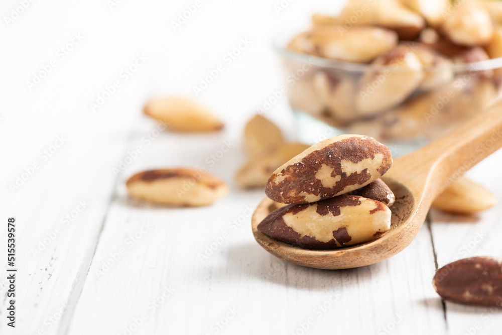 Brazil nuts on wood spoon and space for text on white wooden background, Brazil nuts on wood spoon and space for text on white wooden background,