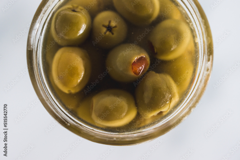 pantry jar with green stuffed olives in close-up, simple staple ingredients pantry jar with green stuffed olives in close-up, simple staple ingredients